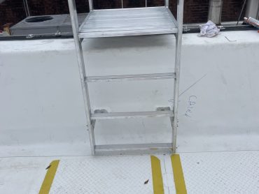 Roof access ladders installed to specifications on a TPO roof